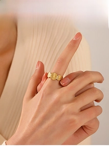 Detailed macro view of the golden three-disk sunburst embossed ring on model hand