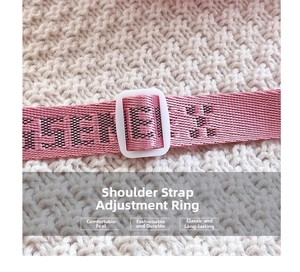 Macro detail of a pink fabric shoulder strap with black letters and an adjustable buckle