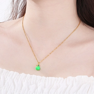 Detailed view of a green enamel apple pendant on a gold-plated stainless steel chain