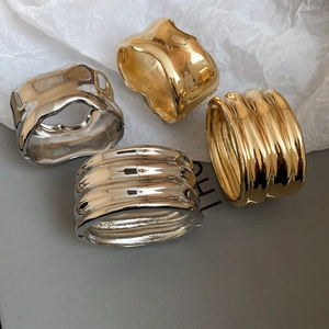 Macro shot of liquid metal style gold and silver bangles with irregular hammered texture