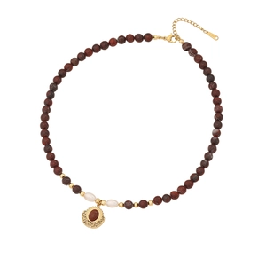 Handmade necklace featuring dark red natural stone beads and gold filigree oval pendant