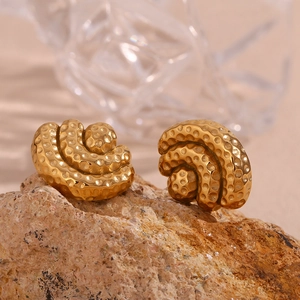Macro view of gold-plated 18K stainless steel hammered fan earrings on a stone base