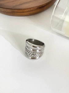 Detailed macro view of silver layered band ring with intricate rope texture and high polish finish