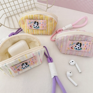 Close-up of colorful tweed earphone cases with cartoon patches and woven lanyards