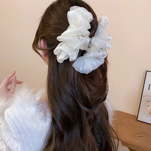 Detail of white organza bow hair claw clip with rhinestones worn on hair