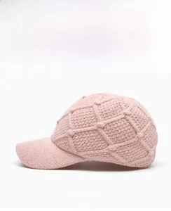 Close-up of the light pink knitted baseball cap showing the detailed diamond weave pattern