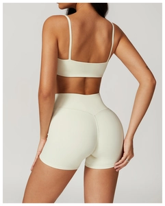 Rear view of cream-colored sports set showing slim fit racerback bra and high-waist shorts