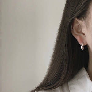 Minimalist S925 sterling silver U-shaped hoop earrings on model with a sleek silver finish