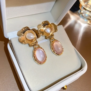 Detail of vintage French flower earrings with pearls and pink resin in a jewelry box