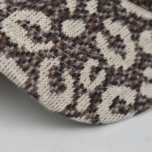 Macro shot of leopard print knit texture and stitching detail on the winter baseball cap
