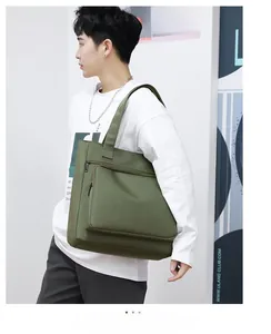 Detail view of olive green waterproof nylon tote bag with functional zippers on model