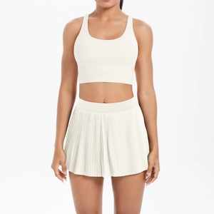 Detail of creamy white tennis set with U-neck sports bra and pleated mini skirt for fitness