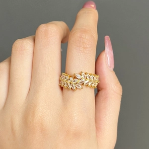 Detail of gold wheat ear ring with marquise zircon stones worn on finger
