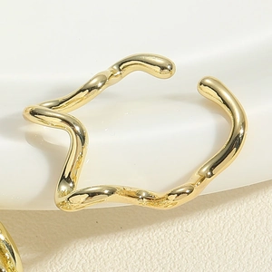Macro view of irregular molten wave ring with polished gold-tone mirror finish