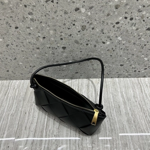 Top view of black woven leather handbag showing gold zipper and texture details