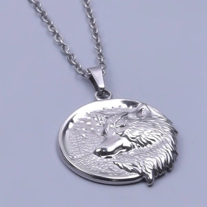 Detail of silver wolf head relief pendant on stainless steel chain with polished finish