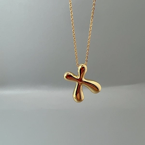 Macro shot of polished gold-finished cross pendant with a sleek O-chain link necklace