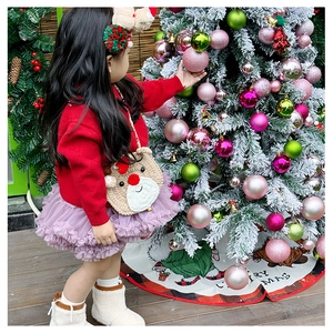 Détail d'un enfant portant un sac renne au crochet avec pull rouge et tutu
