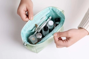 Top-down view of open light green nylon toiletry bag showing internal storage capacity
