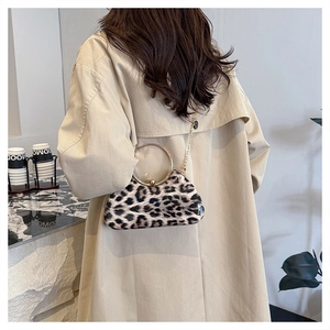 Detail of leopard print evening bag with golden ring handle and elegant metal chain