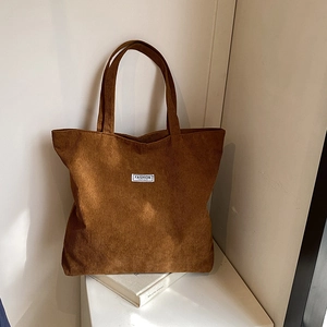 Detail shot of brown corduroy tote bag texture with white Fashion Instinct label