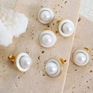 French style vintage pearl stud earrings with gold metal base on natural stone background