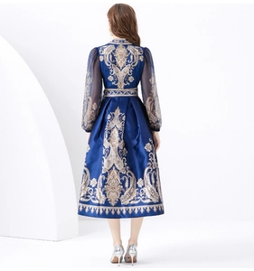 Macro view of navy satin dress with gold paisley print and sheer lantern sleeves