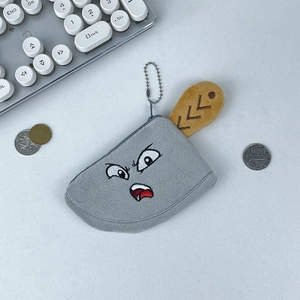 Macro detail of plush knife coin purse with angry face embroidery and metal bead chain