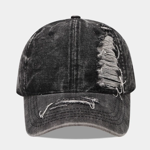 Distressed wash denim baseball cap with vintage ripped details and frayed brim style