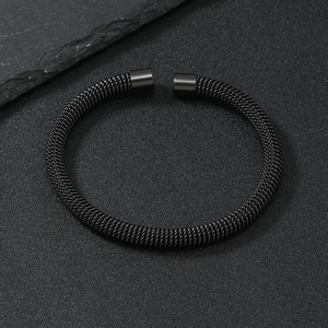 Close-up of matte black stainless steel woven mesh open bangle with textured details