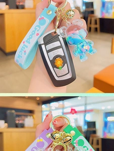 Detail of creative cartoon bear liquid sand keychain with Good Luck wrist strap and bell