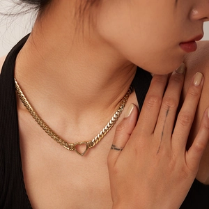 Close-up of a gold-plated stainless steel cuban chain necklace with a hollow heart pendant