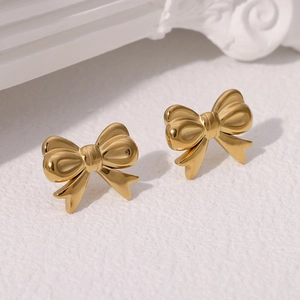 Elegant 18k gold plated stainless steel bow stud earrings on a white marble background