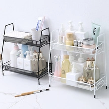 Black and white metal wire bathroom organizers on a white marble countertop surface