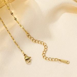 Detailed close-up of golden stainless steel necklace chain and lobster clasp on silk