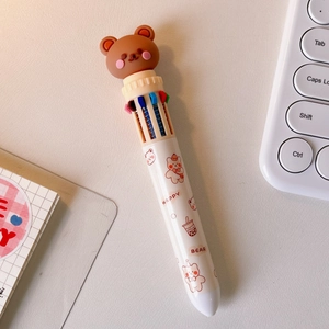 Detail showing white multi-color ballpoint pen with brown bear head and cartoon patterns