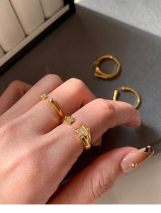 Detailed shot of gold plated star rings with sparkling zircons on a woman's hand