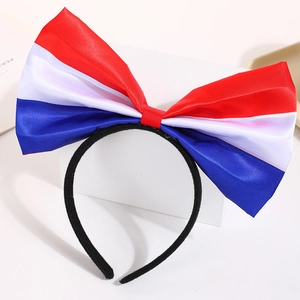 Close-up of a red, white and blue satin bow headband on a white display stand