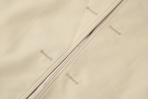 Detail of high-density twill fabric and reinforced buttonhole stitching on trench coat