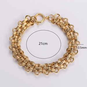 Gold stainless steel braided chain bracelet 13.5mm wide and 21cm long on gray background