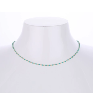 Detail of s925 silver gold chain necklace with turquoise beads on a white bust