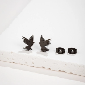 Minimalist matte black flying bird stud earrings for women on a textured stone block