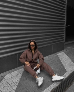 Brown oversized zip-up hoodie and matching joggers set styled in an urban street photoshoot