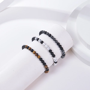Détails de bracelets en œil de tigre et pierres mates sur des socles géométriques