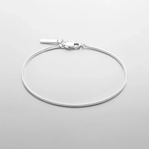 Détail d'un bracelet maille serpent argenté avec fermoir mousqueton et étiquette
