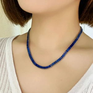 Elegant silver necklace featuring rectangular blue zircon stones on model neck