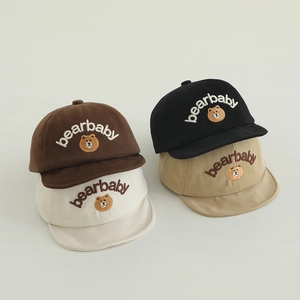 Détail montrant la broderie bearbaby et les motifs d'ours sur quatre bonnets en coton pour bébé