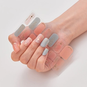 Detailed view of laser bronzing nail stickers with pink and grey glitter patterns