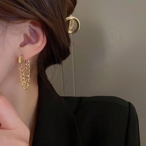 Close-up of a model wearing golden chunky chain earrings with a minimalist square base