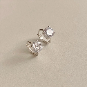Macro detail of silver four-prong earrings with sparkling white cubic zirconia
